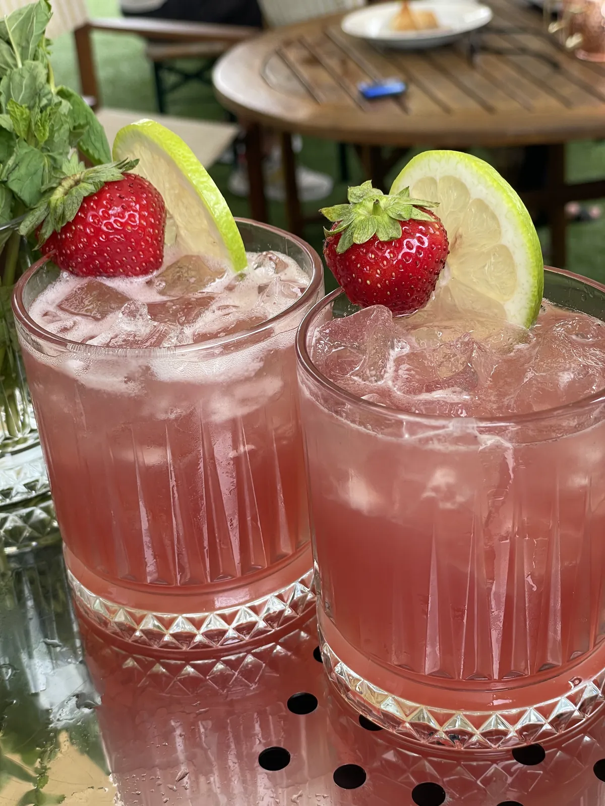 Zwei rosa Cocktails mit Erdbeeren und Limetten
